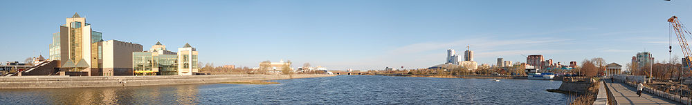 Слева — краеведческий музей, посередине — река Миасс, справа — торговый центр и современные высотные жилые здания.